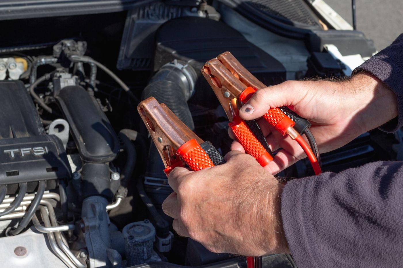Jumper leads being connected to a car battery