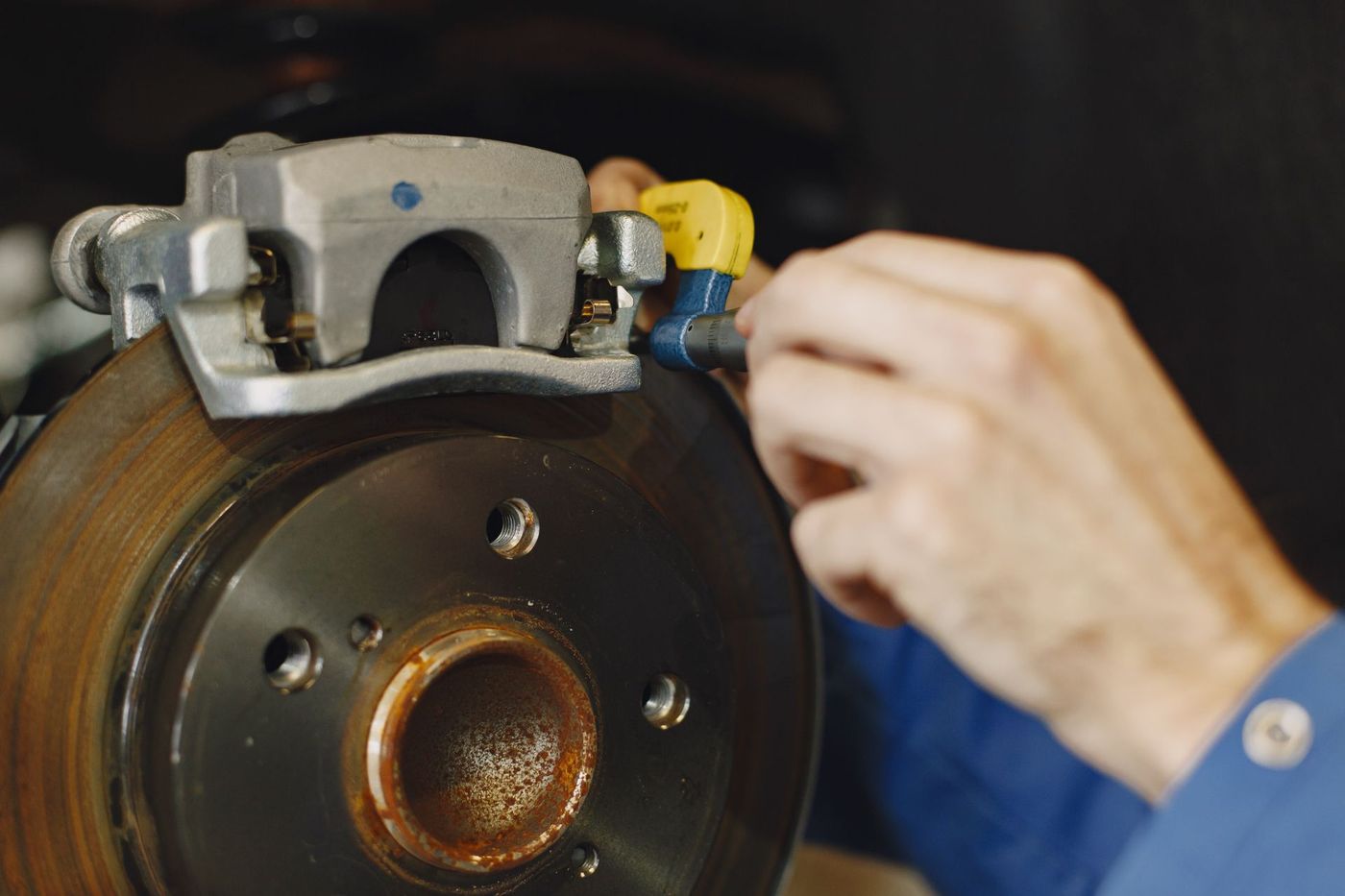 Close-up of a vehicle disc brake and caliper with the wheel removed